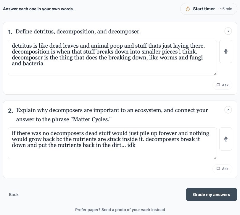 The same student typing biology answers in their own words, with a link offering to send a photo of paper work instead.